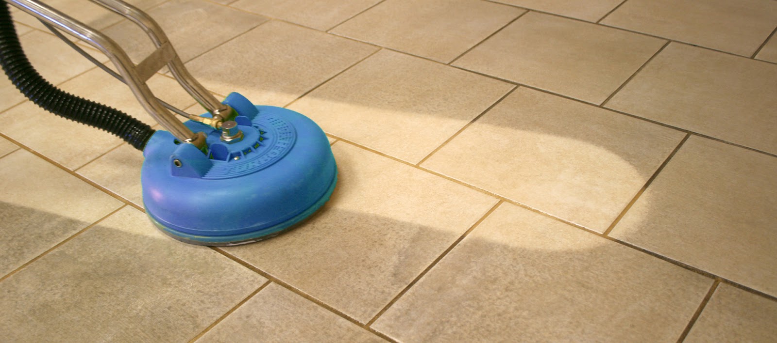 Tile and grout being steam cleaned in a shower
