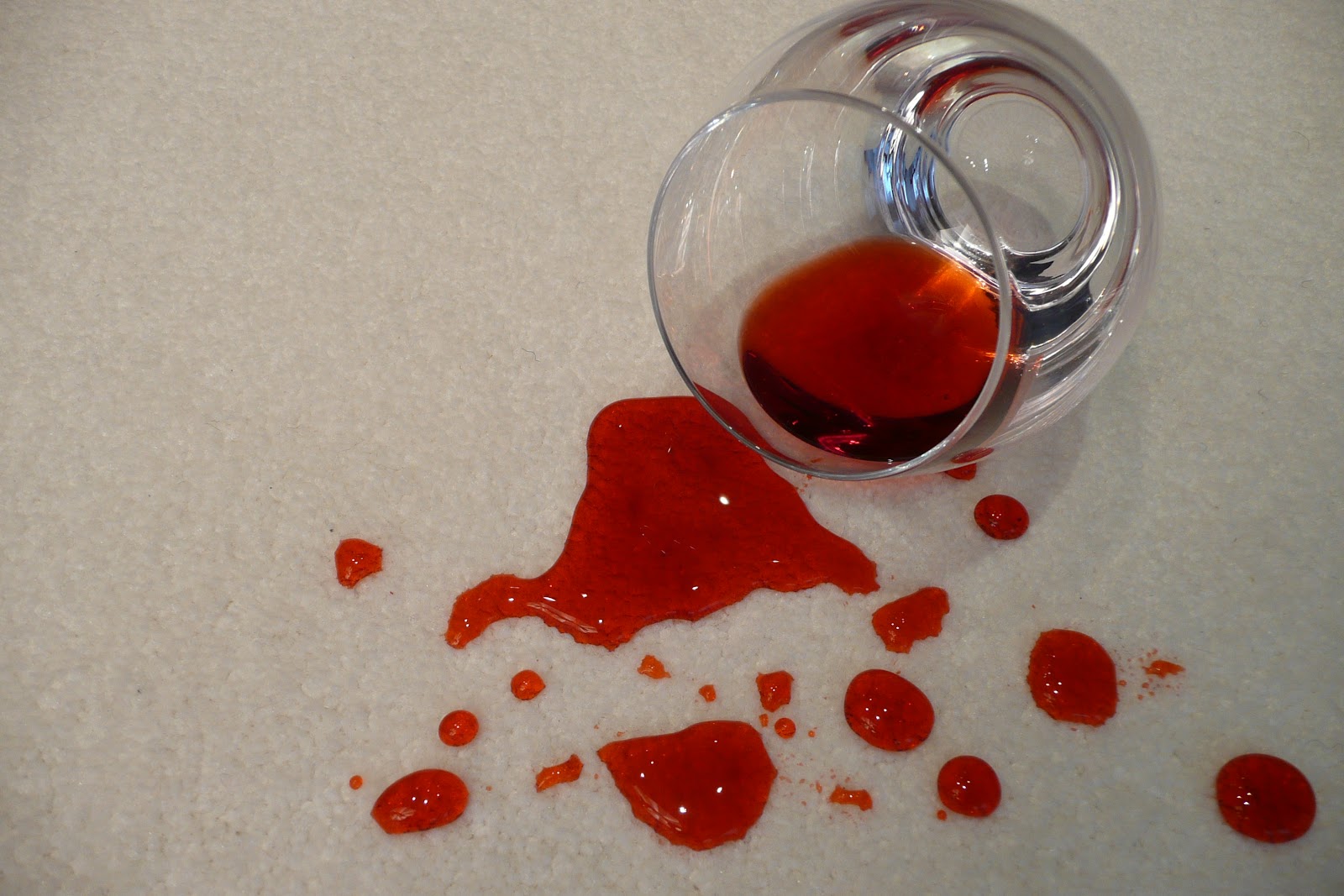 Red wine spilled on beige carpet before treatment